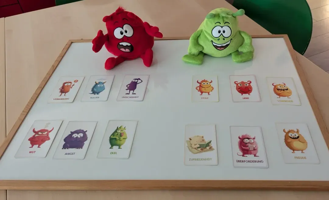 Gefühlskarten und zwei Plüschfiguren auf einem Tisch