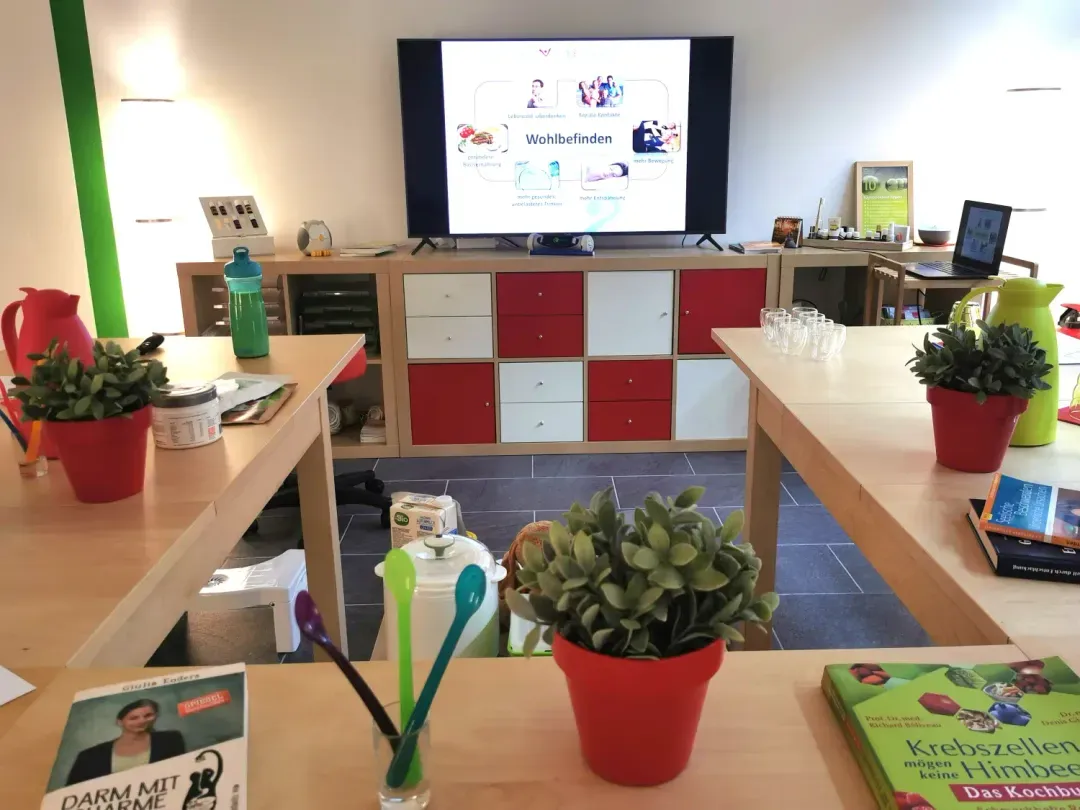 Vorbereiteter Seminarraum mit Bildschirm zum Thema Wohlbefinden
