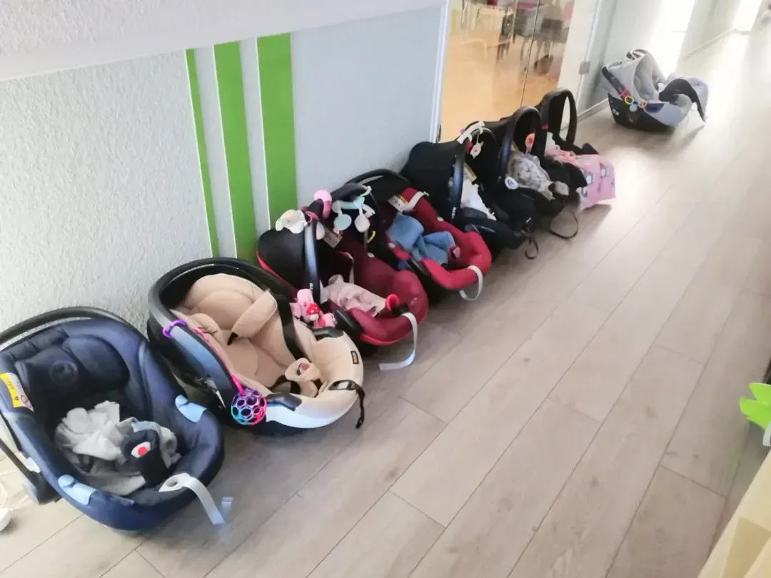 Babyschalen reihen sich im Flur während eines Elternkurses