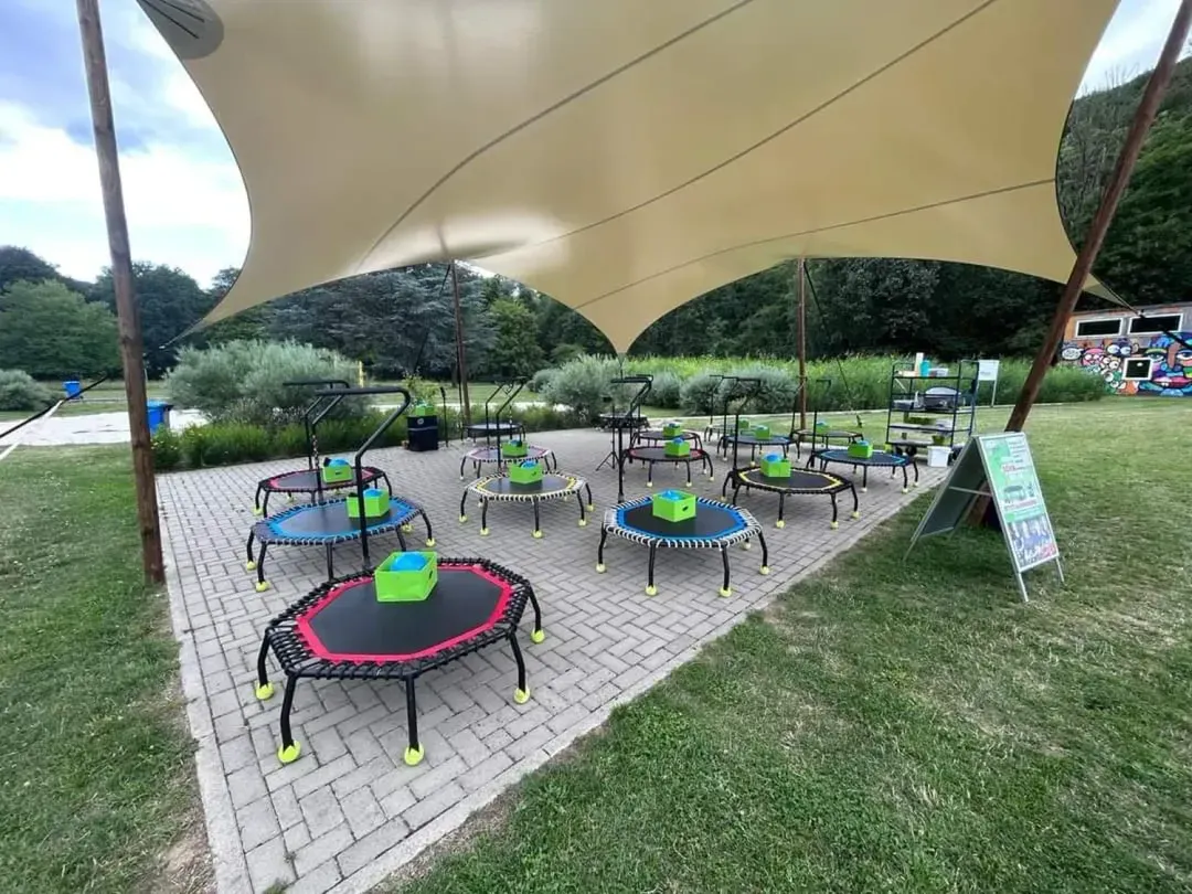 Trampoline unter einem Sonnensegel auf einer Wiese